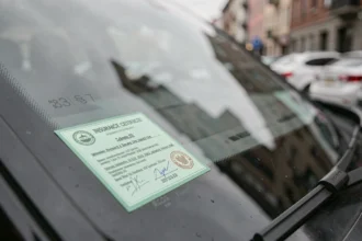 Vignette verte d'assurance automobile collée sur le pare-brise d'une voiture, vue de l'extérieur