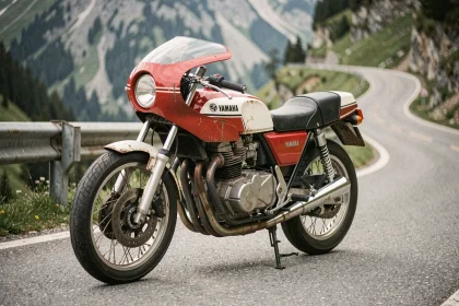 Yamaha RDLC 350 occasion garée sur une route de montagne sinueuse, vue 3/4 avant révélant le moteur deux-temps et les pipes d'expansion emblématiques